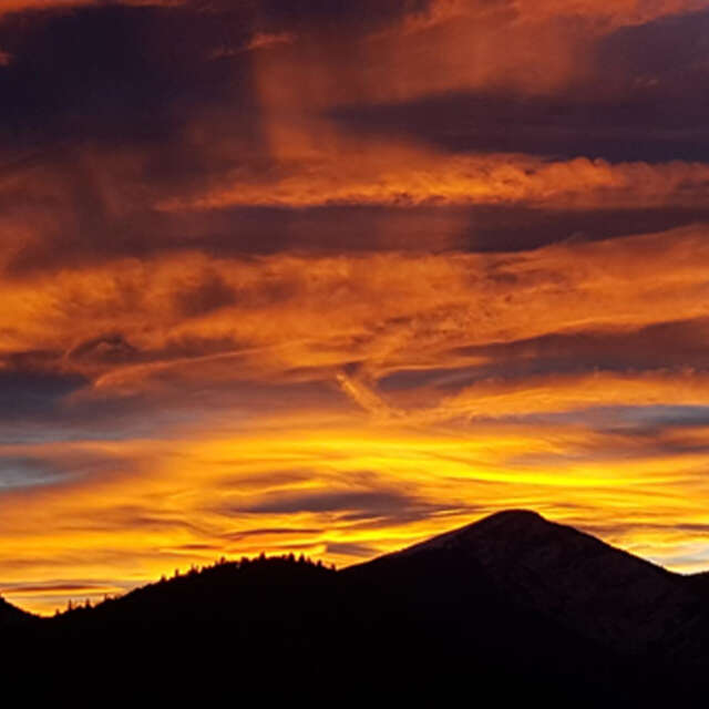 Contempler le coucher de soleil en raquettes à neige